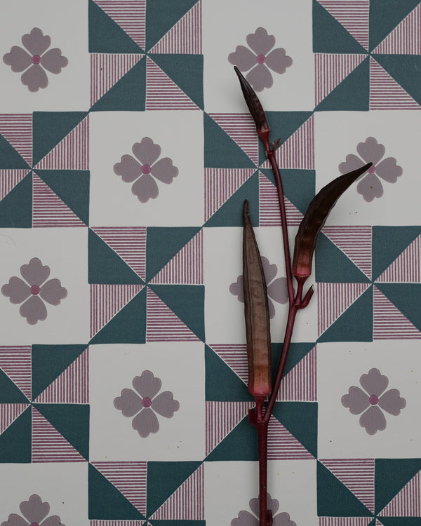 Parita borrows from the bold geometry of vintage quilts, where simple shapes come together to create movement and rhythm. The pinwheel forms are softened by fine hand-drawn stripes and a sweet four-petal flower, bringing a touch of whimsy to the structure. Graphic yet nostalgic, it feels like an old textile reimagined with a playful spirit.