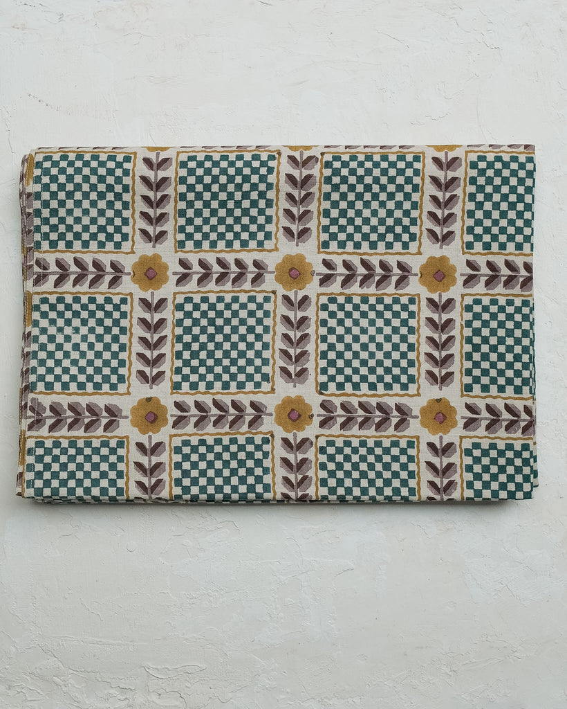 Rectangular fabric sample with a checkered and floral pattern on a white background