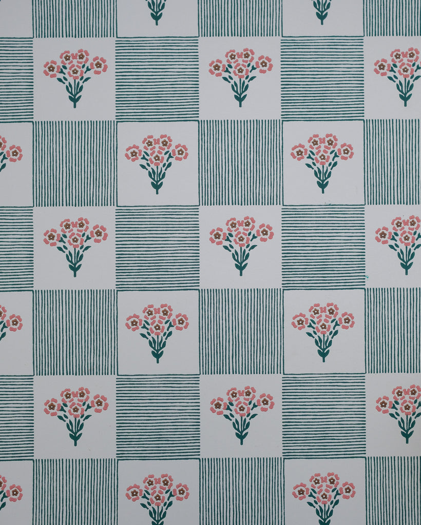 Shabana plays with the nostalgia of old patchwork and hand-stitched quilts, where simple florals and stripes come together in an easy rhythm. Tiny bouquets soften the geometry, while the hand-drawn lines give the pattern a warmth and imperfection that feels collected rather than composed.