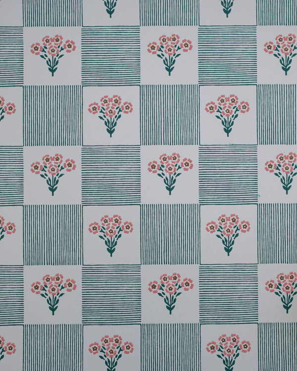 Shabana plays with the nostalgia of old patchwork and hand-stitched quilts, where simple florals and stripes come together in an easy rhythm. Tiny bouquets soften the geometry, while the hand-drawn lines give the pattern a warmth and imperfection that feels collected rather than composed.