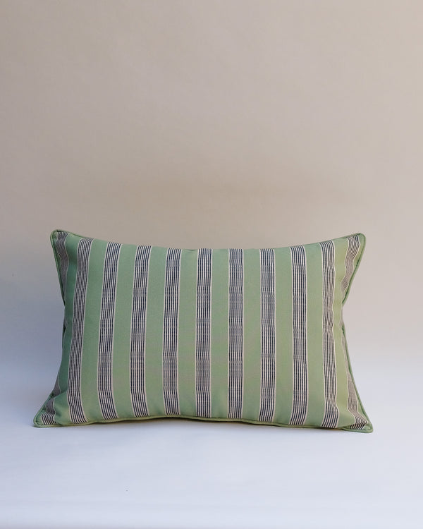 A rectangular throw pillow with vertical stripes in sage green, gray, and thin white lines, set against a plain beige background.